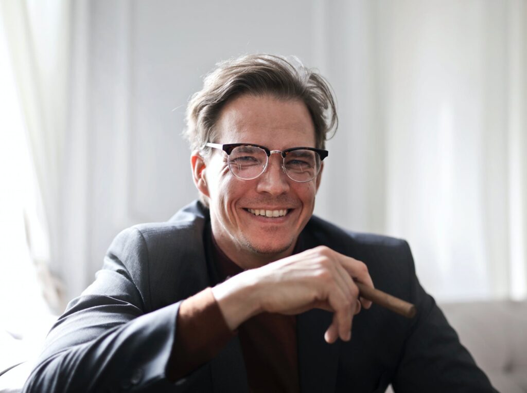 adult man with cigar smiling at camera