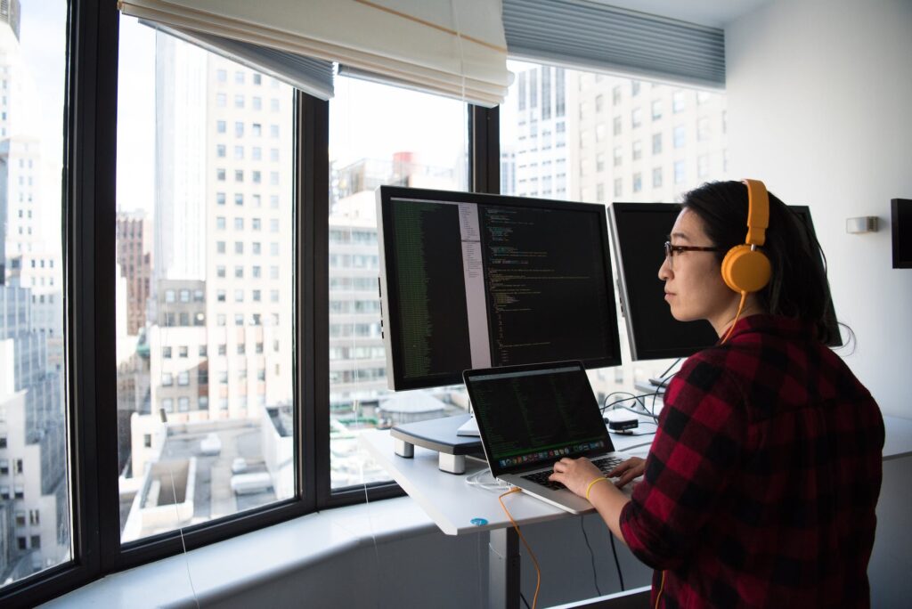 woman sitting while operating macbook pro